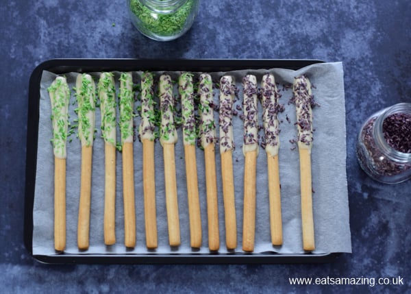 Edible Monster Breadstick Wands recipe - step 2 sprinkle with homemade Halloween coconut sprinkles