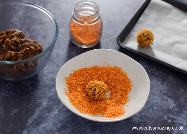How to make pumpkin shaped pumpkin spice energy bites - step 2 roll walnut sized pieces in orange coconut sprinkles