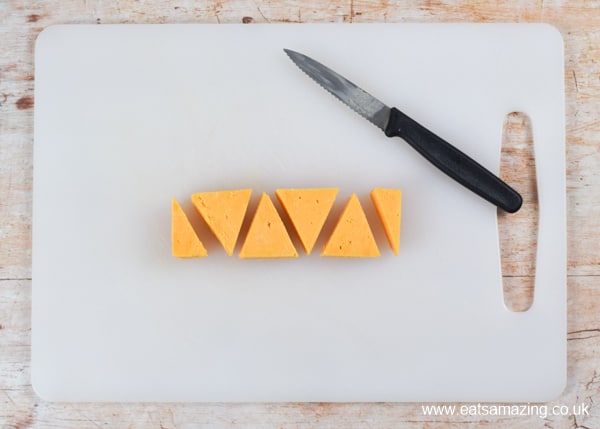 How to make a simple cheese Christmas trees snack - step 1 cut triangles from cheese