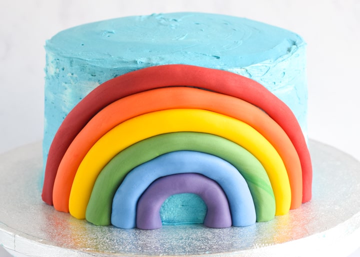 How to make a fondant rainbow cake decoration - step 8 repeat until complete rainbow is on the cake