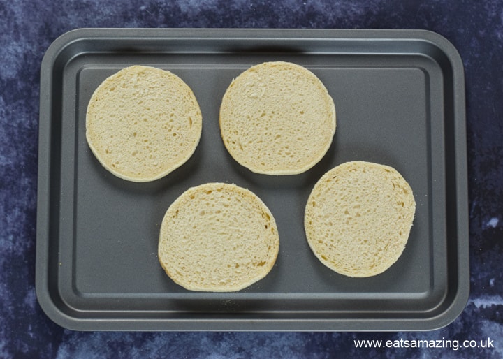 How to make Halloween Mummy Pizzas - step 1 slice muffins and place on a baking tray