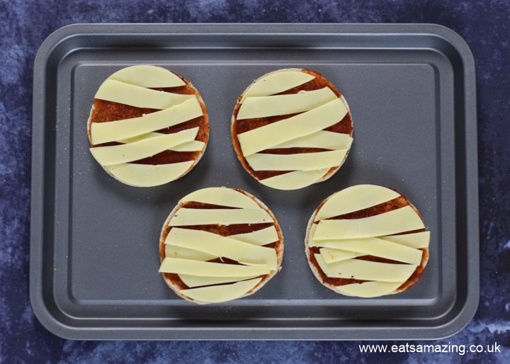 How to make Halloween Mummy Pizzas - step 4 arrange cheese strips on pizza