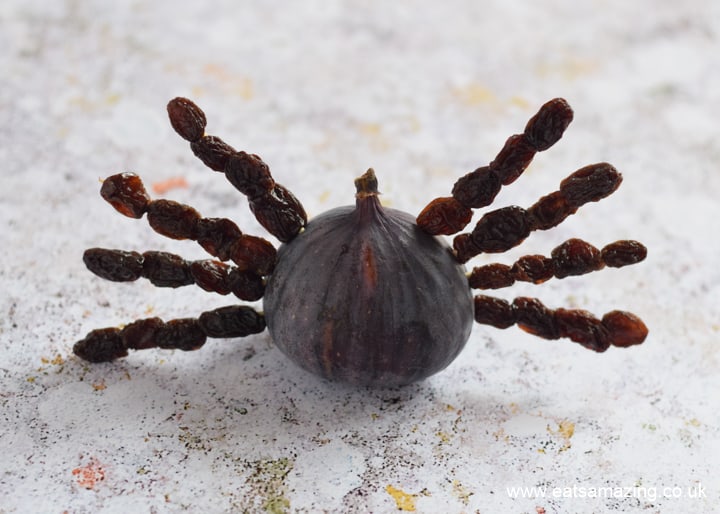 Cómo hacer bocadillos de araña de higos y pasas para Halloween: paso 2 empujar las patas de pasas en los higos